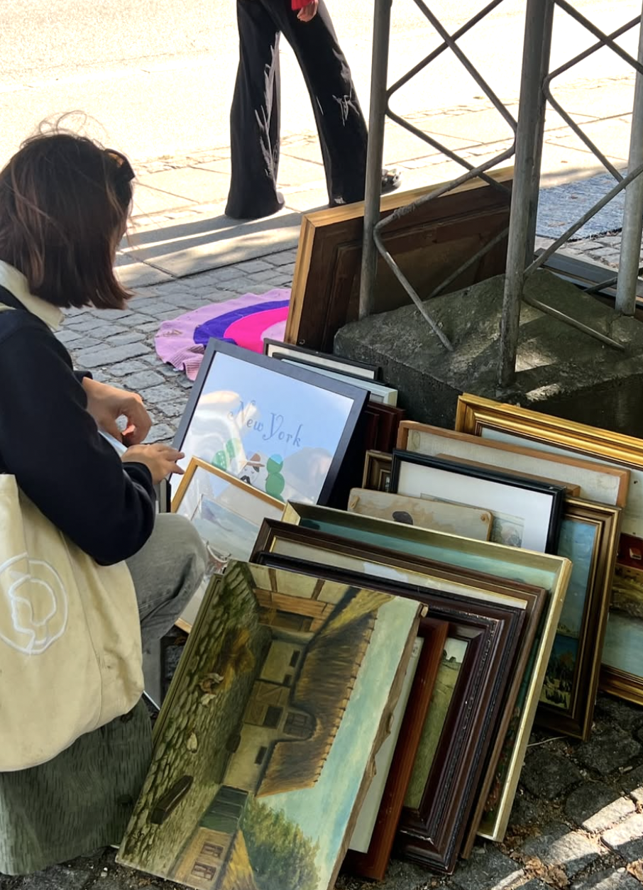 Browsing framed art at John Winthers Plads flea market.
